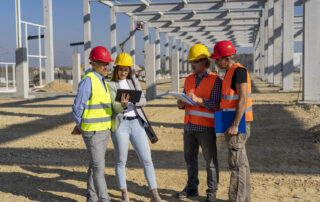 Construction-Project-Manager-And-His-Team-Discuss-A-Project-On-Construction-Site