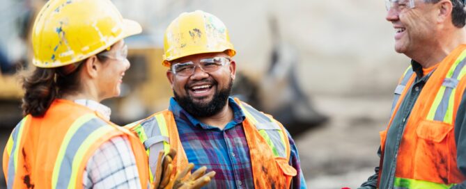 This is a photo of three construction workers having a conversation.