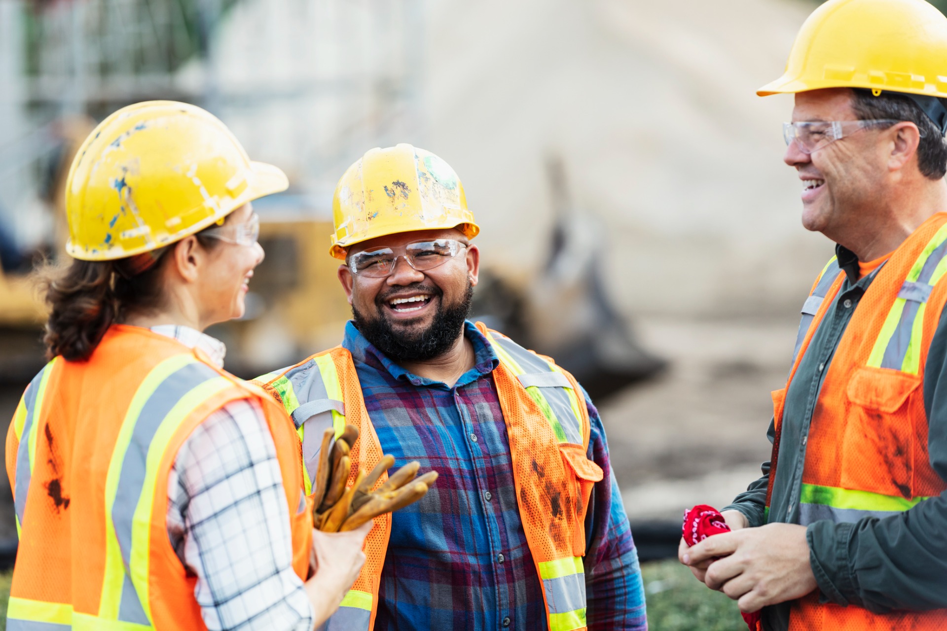 This is a photo of three construction workers having a conversation.